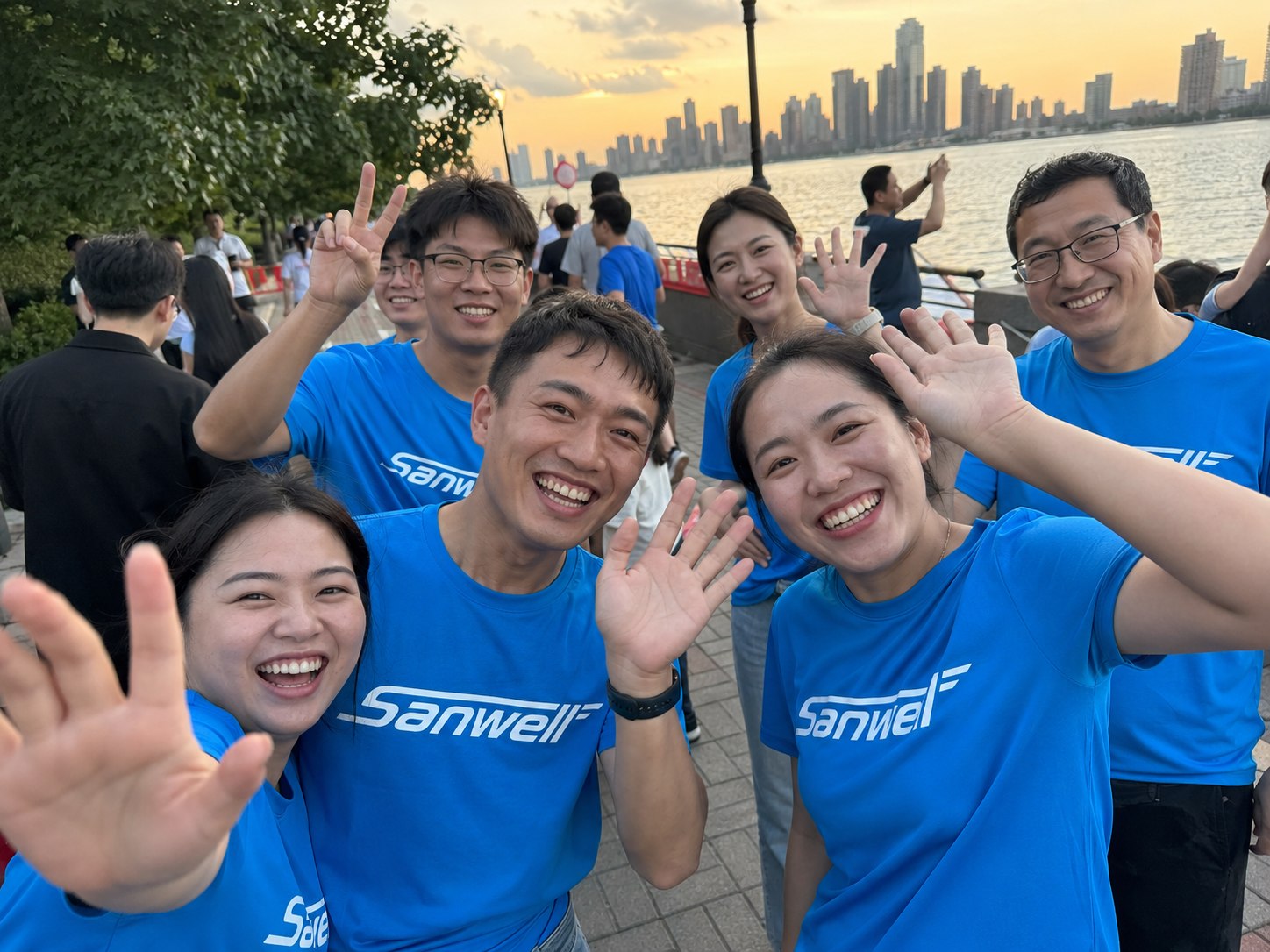 SANWELL LOGISTICS team members wearing blue shirts during a riverside team activity