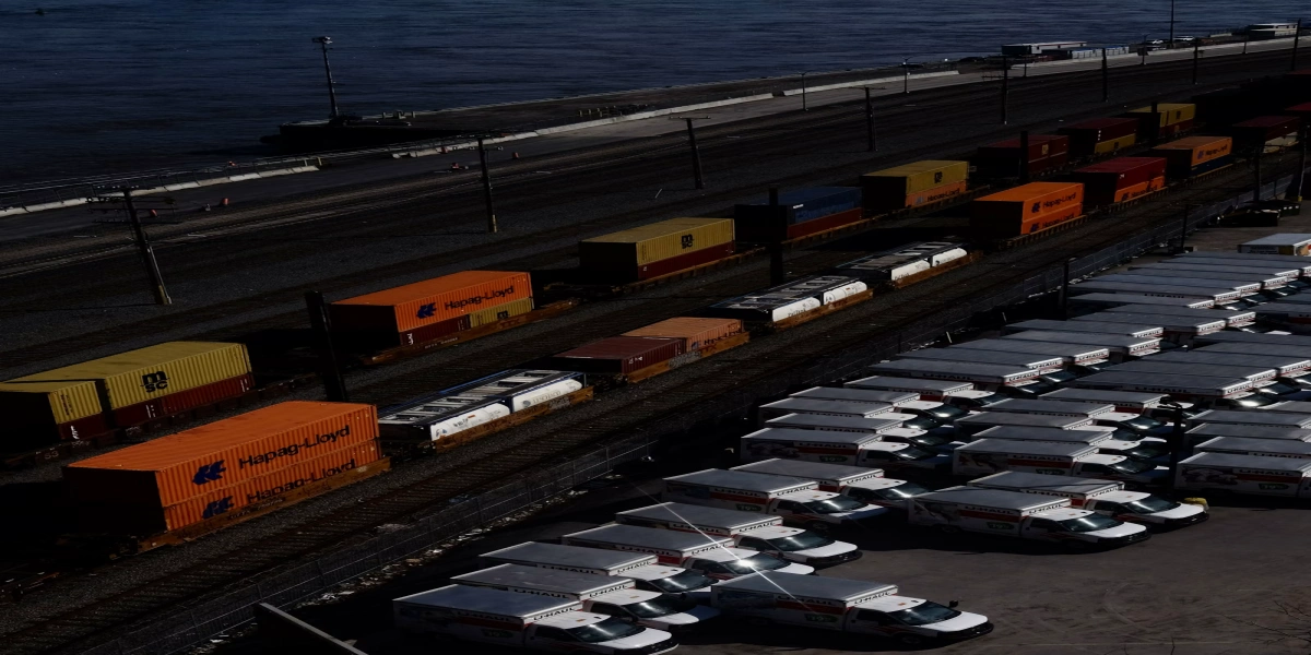 Cargo containers staged with trucks and rail equipment at a port terminal