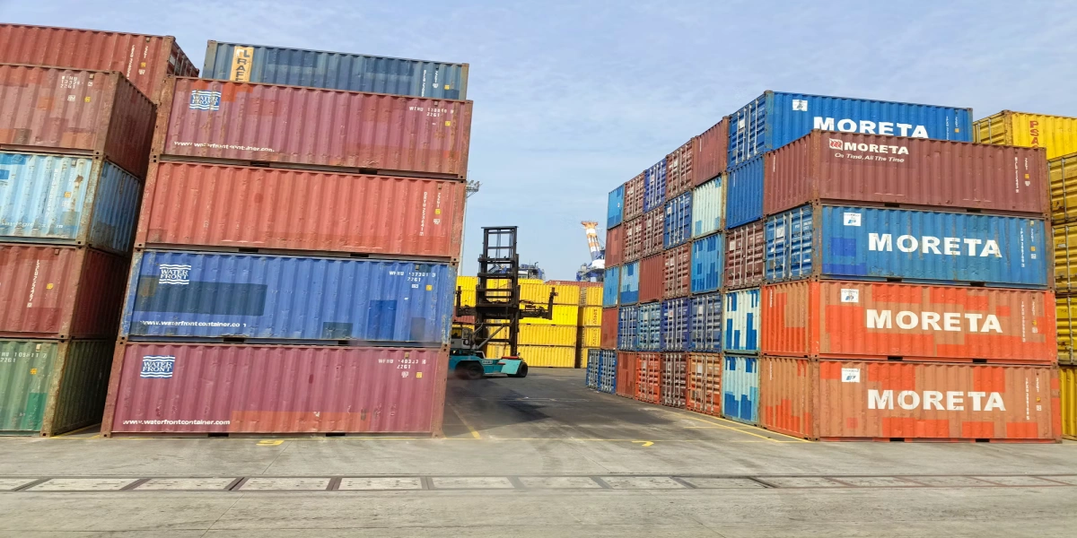 Forklift moving containers at a terminal during export-side freight handling